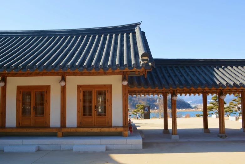 a building with wood doors, wooden columns and a blue sky