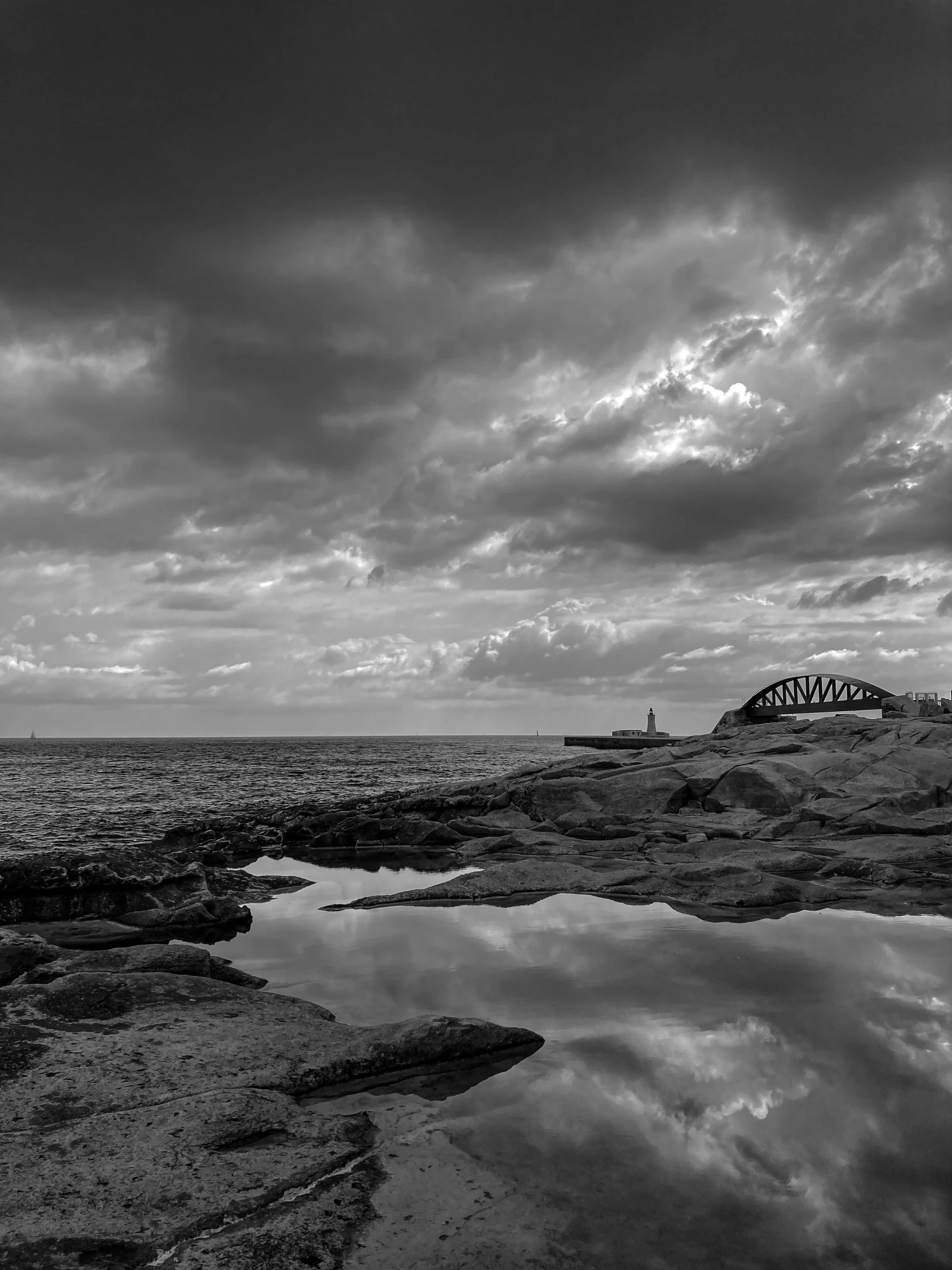 a black and white po of the ocean on a cloudy day