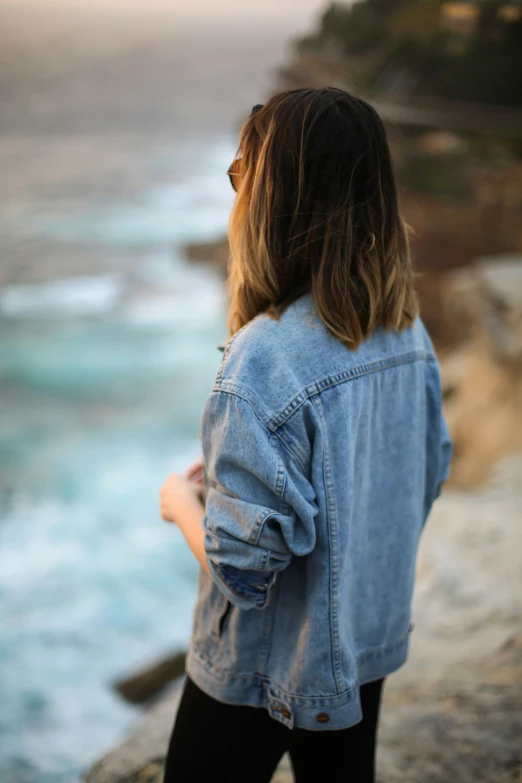 a woman in black leggings stands on a cliff