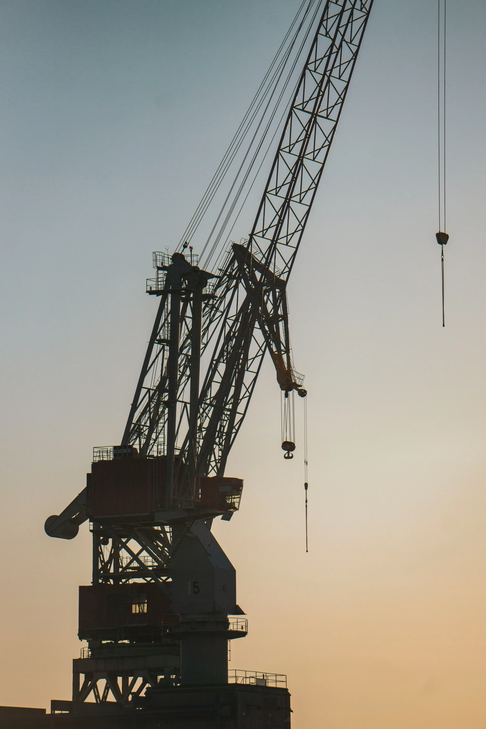 a crane is suspended over several buildings on the horizon