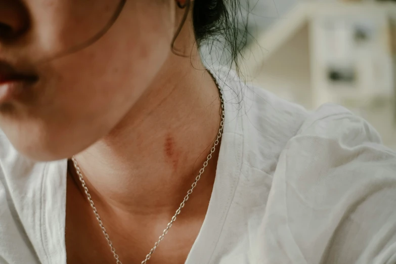 a woman wearing a necklace with a yellow bird on it