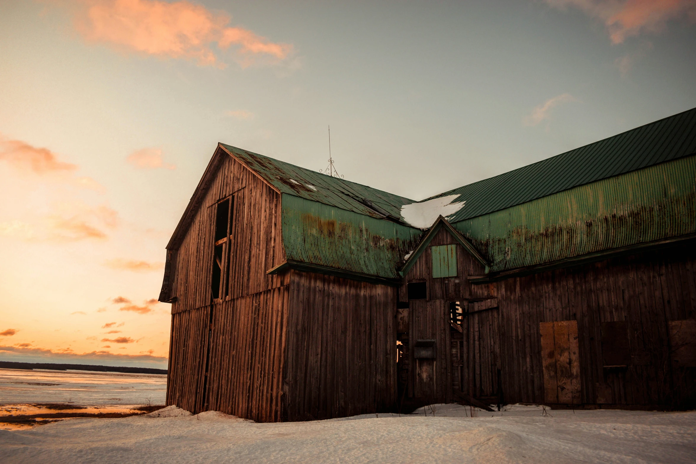 the barn has a steeple near it with a green roof