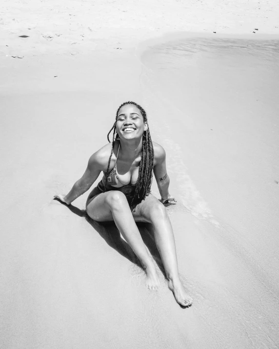 a woman wearing a bikini on the sand at the beach