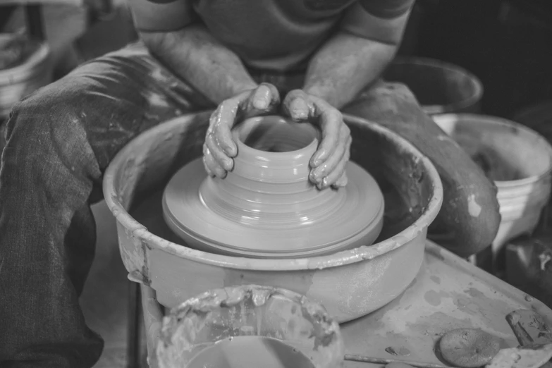 a man potter hands creating a vase on a wheel