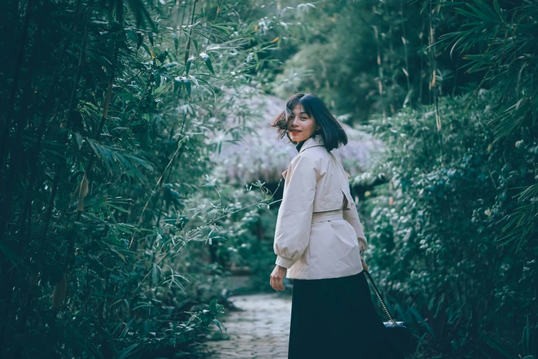 a girl standing in a park with flowers