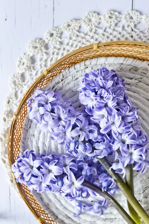 a wicker basket with purple flowers sitting on it