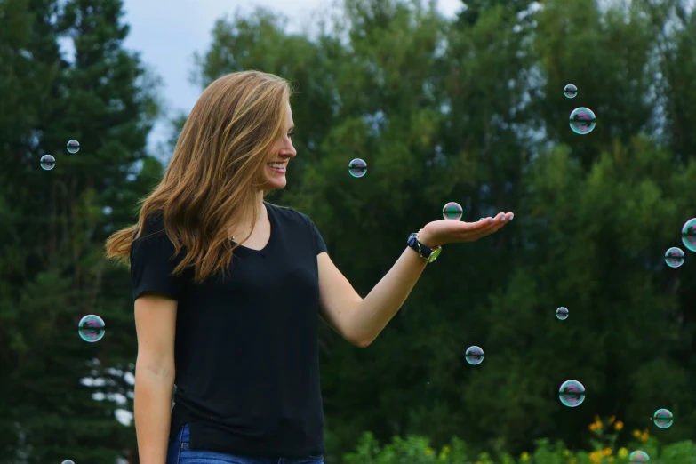 the woman is smiling and blowing bubbles on her finger