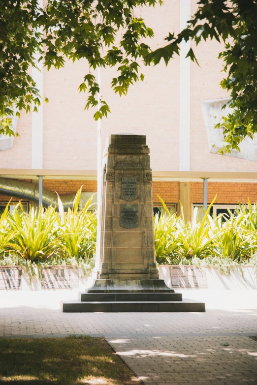 a stone monument sits near a tree