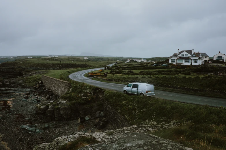 a van is driving along the coastal road