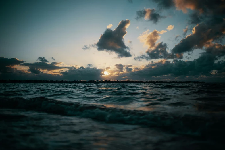 the sun rising over the horizon at sea