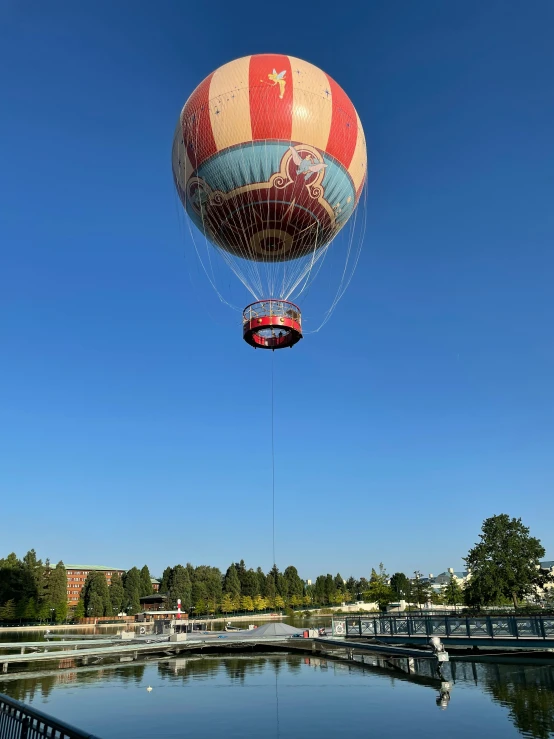 a colorful air ball is in the sky over a lake