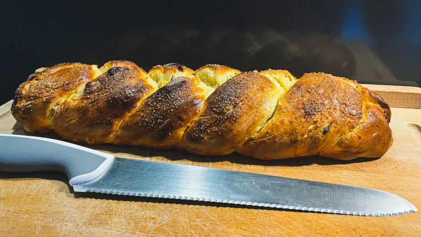 freshly baked ided bread next to a large knife on a  board