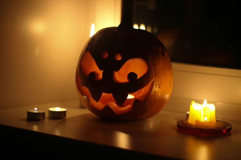 a carved pumpkin sits next to some candles