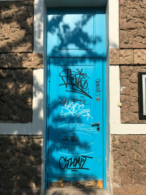 a doorway covered in graffiti in front of a stone building