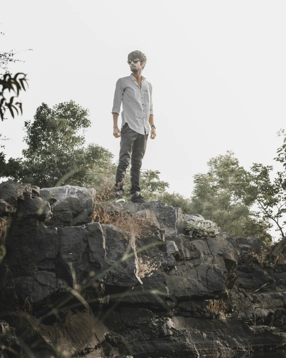 a man standing on the top of a rocky cliff