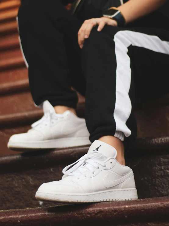 a woman sitting on steps wearing adidas