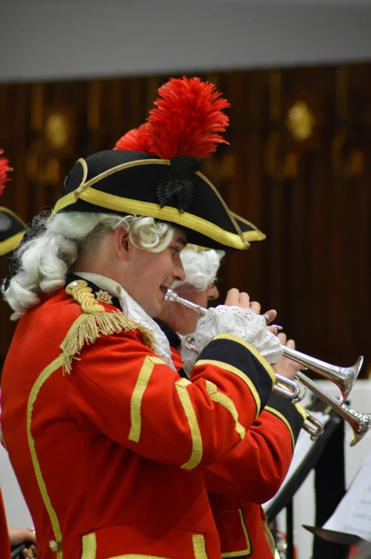 a man in a red uniform plays a trumpet