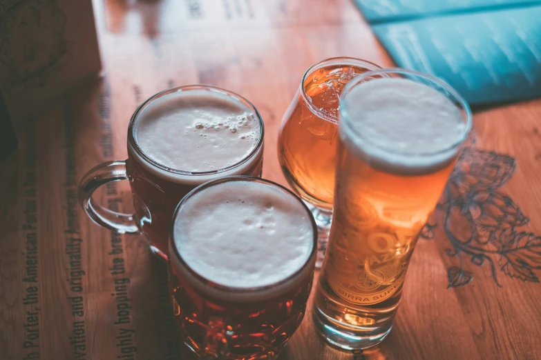 there are three beers sitting in a row on the table