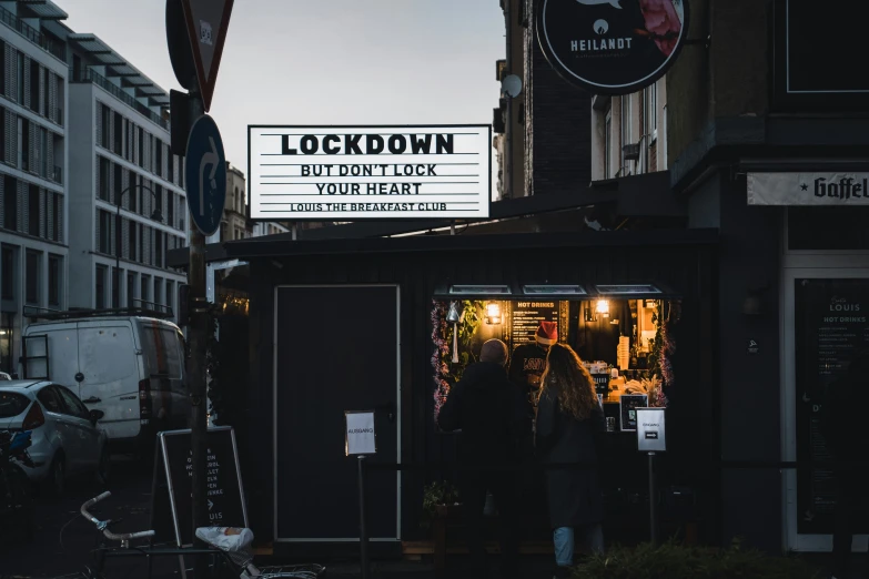 people stand in front of a restaurant at dusk