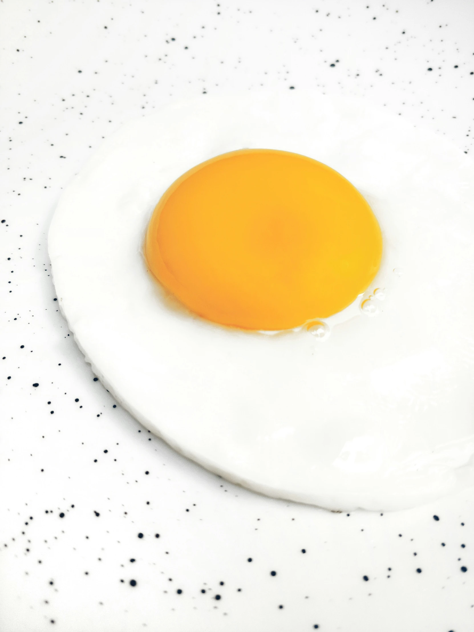 an egg with a fried egg inside on top of a white table