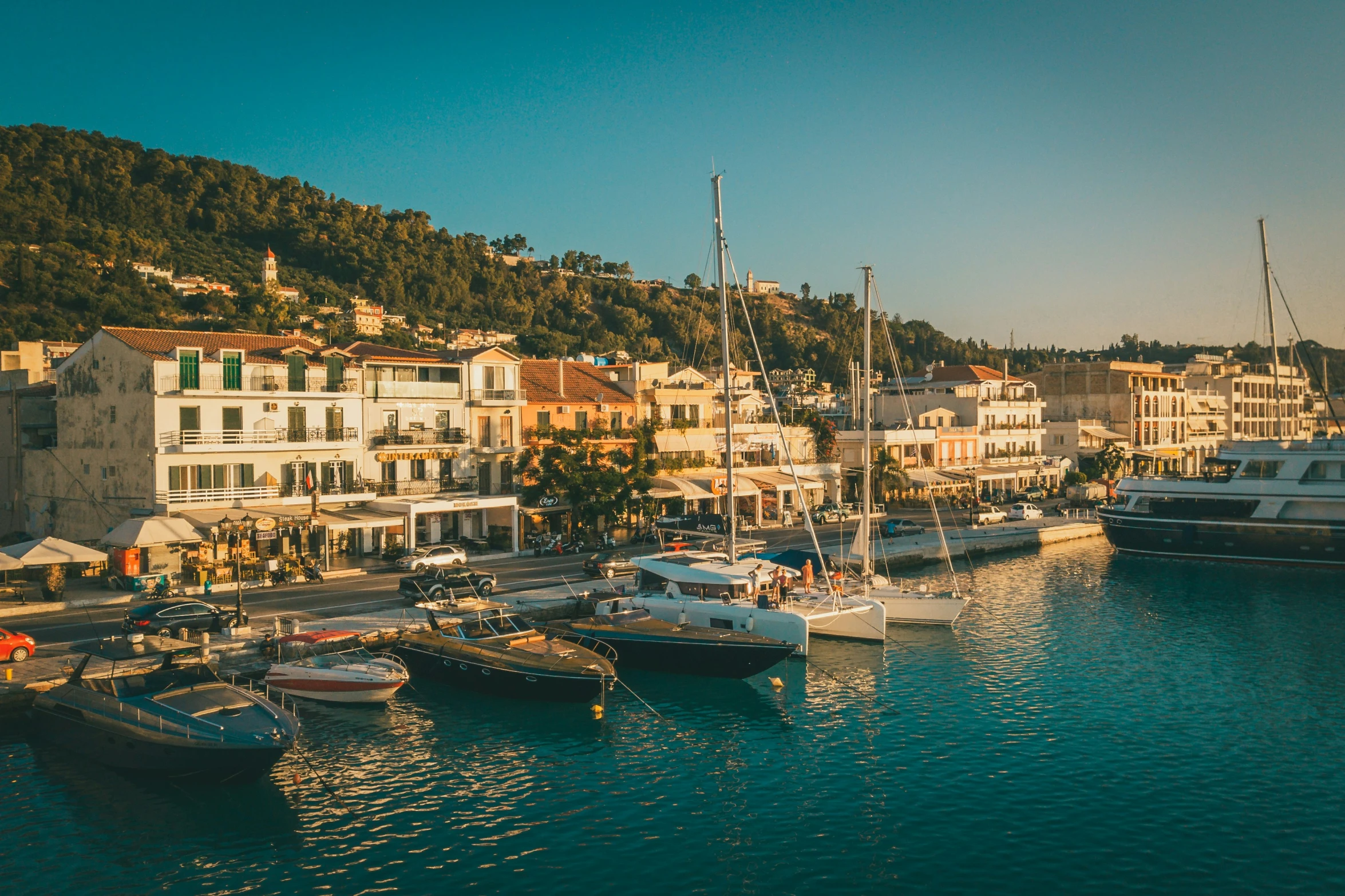 several boats are docked near a town on the shore