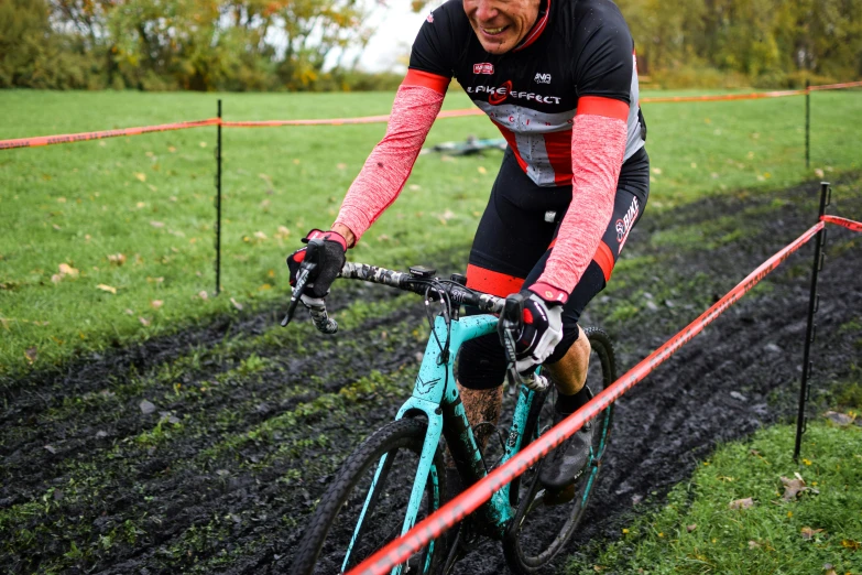 the man is riding his bicycle in the mud