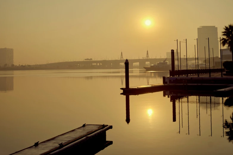 a small boat in a bay with a sun set behind it