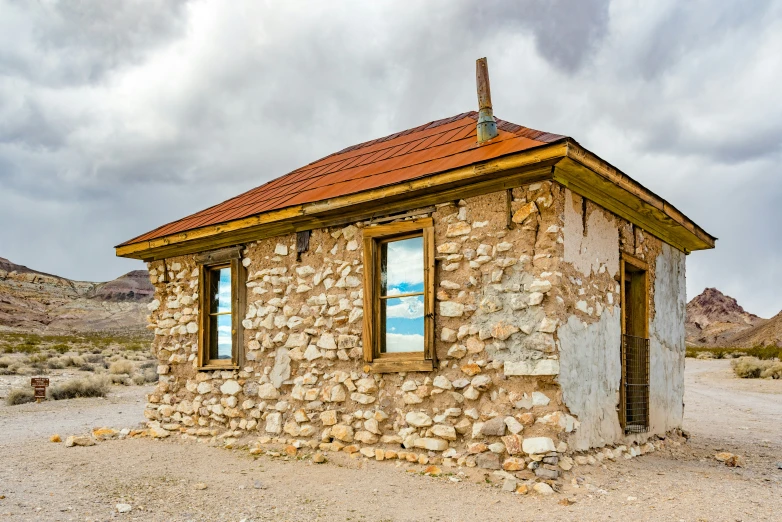 an old house with windows and a roof sits on dirt