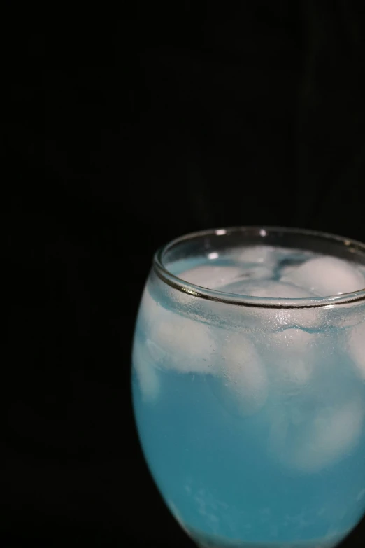 a blue drink in a clear glass on a table