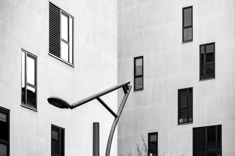 an empty street light in front of white apartment building