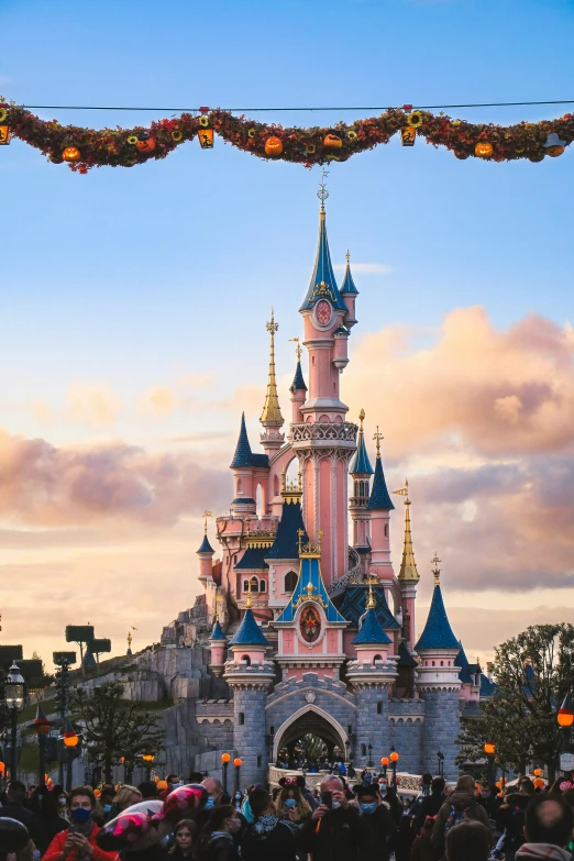 disney castle from below with crowds standing outside