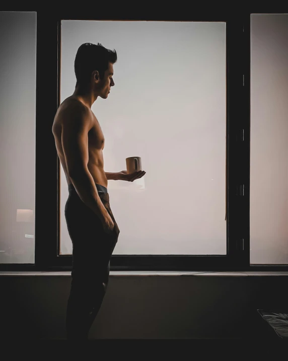 a young man standing on a window sill holding a plate