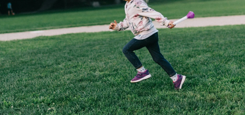 a  in a grassy area swinging a bat