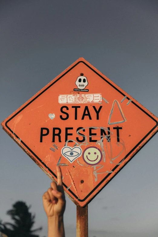 someone points their finger at a stay present sign