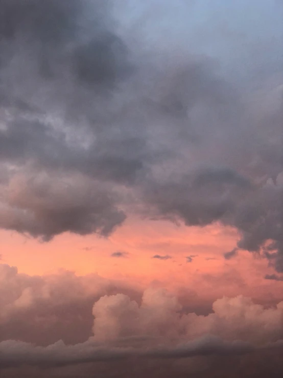 plane in the middle of the clouds with a pink sky