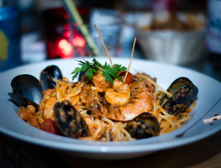 pasta with mussels, meat, and sauce on a table