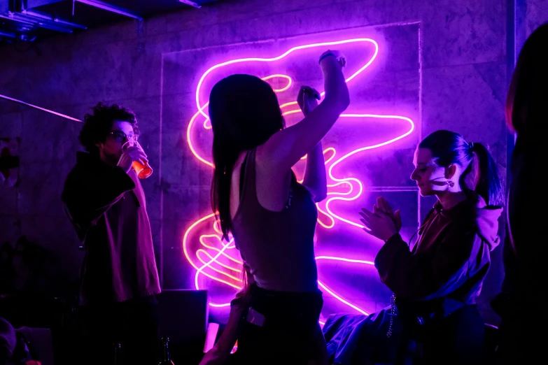 people standing in a darkened room with colorful neon lights