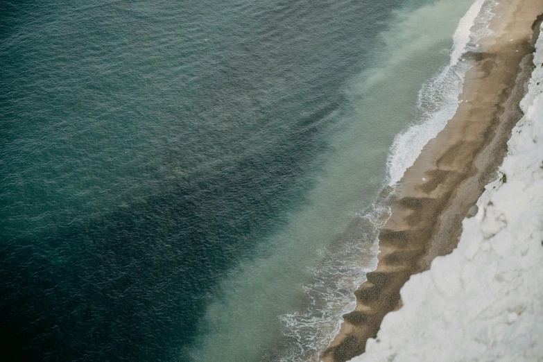 an aerial s of an ocean beach with a bench