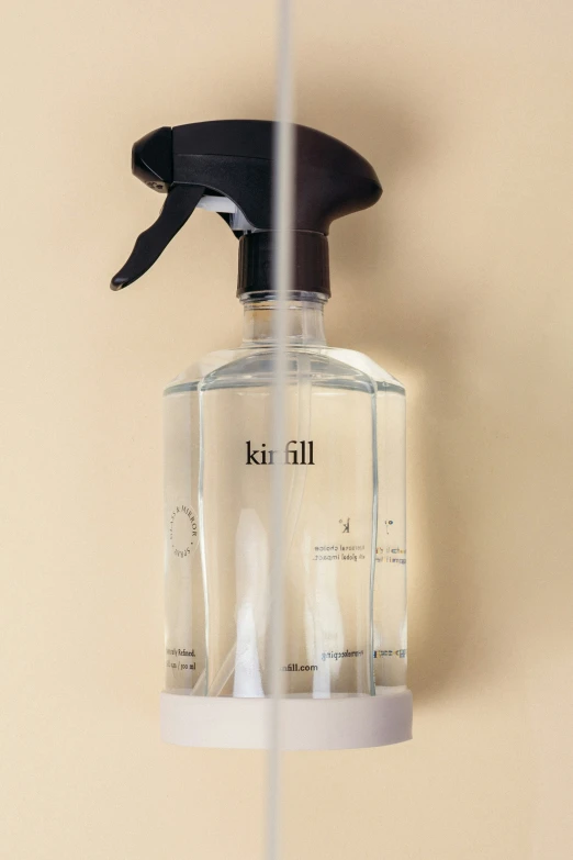 a sprayer bottle with liquid sitting on the side of it