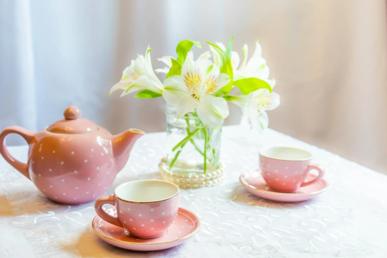 tea set and pitcher sitting on table with white flowers