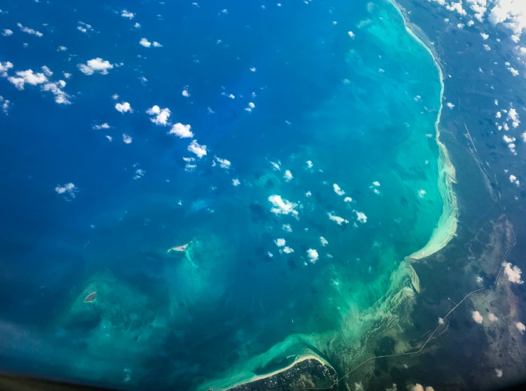 the aerial view of a green ocean and the shore