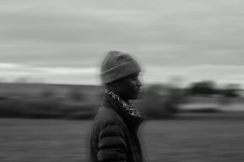 a man in a beanie looks over his shoulder