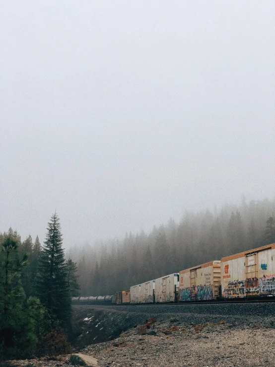 a train travels down the track with trees in the background