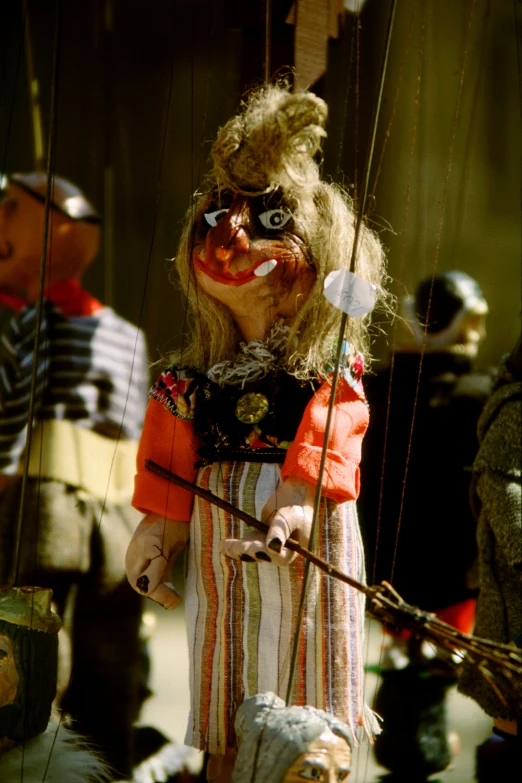 a creepy doll is holding a bow while people watch