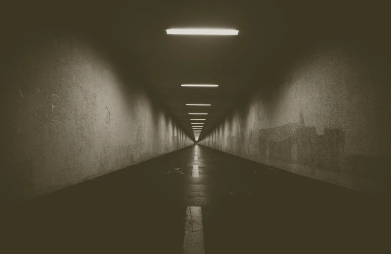 a dark corridor with light shining down and on top of it