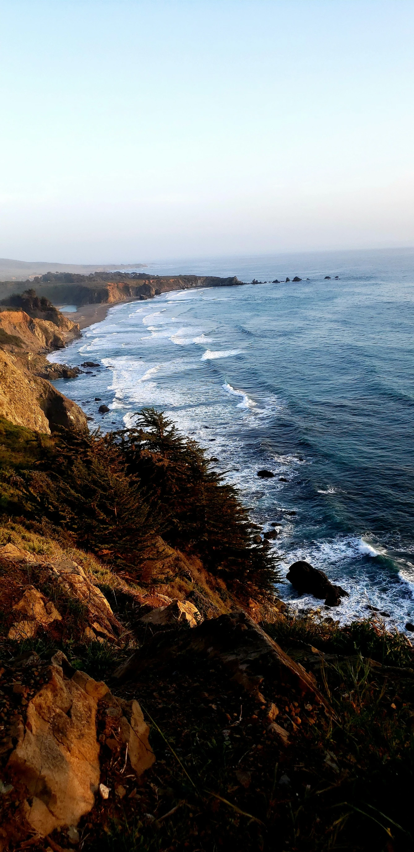 the ocean is calm and serene on a hillside