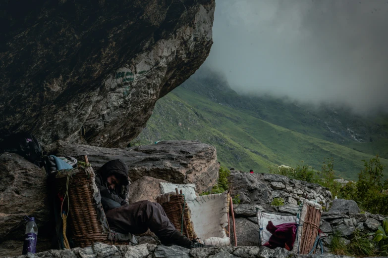 a man sleeping on a pile of hay near some mountains