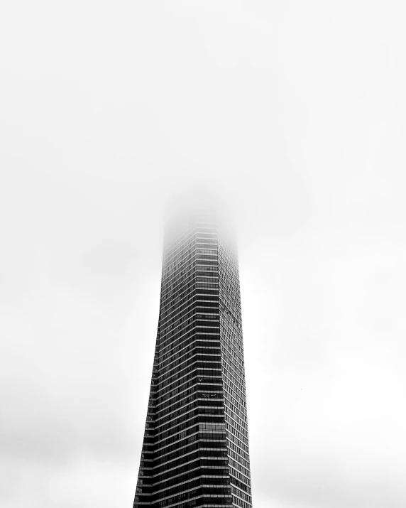 the view of a tall building with a plane flying in the sky