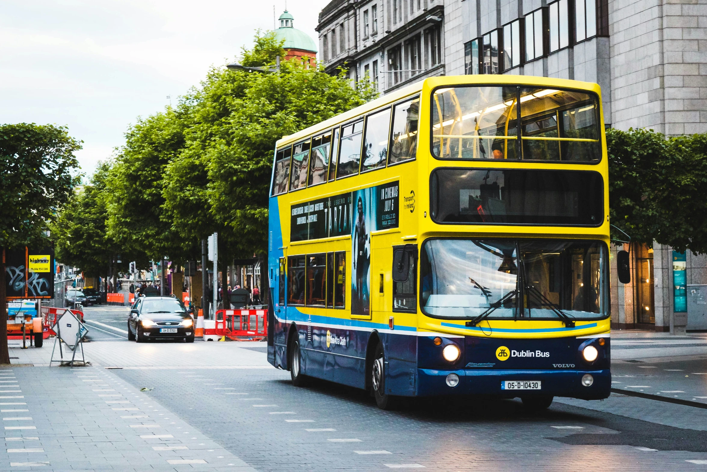 double deck bus on city street with pedestrians near by