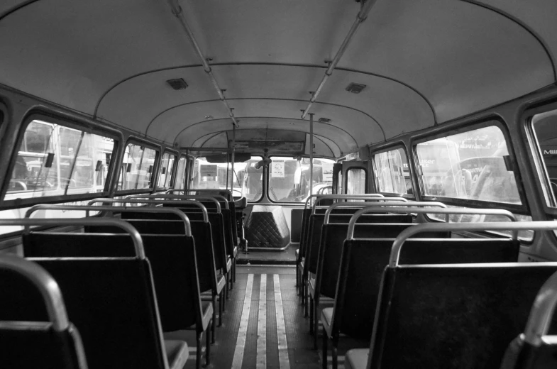 the interior of a bus has rows of seats